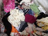 a pile of clothes that is sitting on a bed
