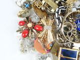 a pile of assorted jewelry on a white surface