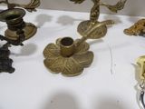many different types of brass candles on the table