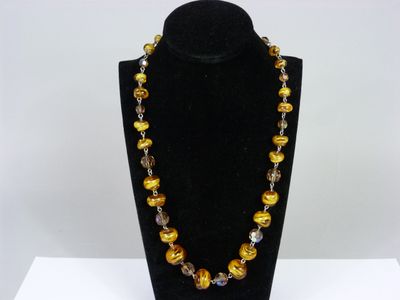 the necklace is made of glass beads and gold colored beads