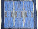 a blue and white silk scarf with a design on it
