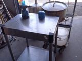 une table en métal sur laquelle est posée une casserole, dans un garage