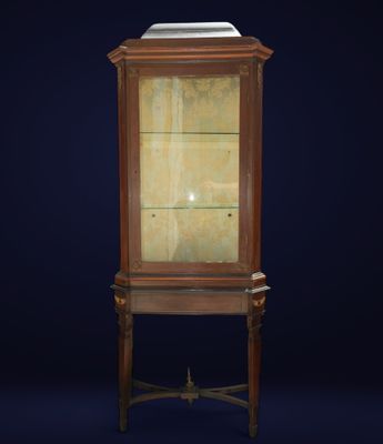 une vitrine ancienne en bois, dotée de portes vitrées et d'un plateau en marbre