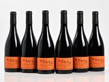 six bottles of wine are lined up in a row on a white surface