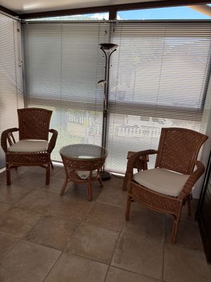 two wicker chairs and a table in the corner of a room