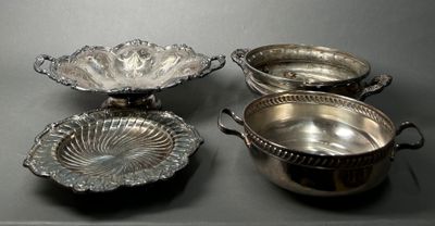 three silver plated dishes on a table with a black background