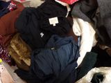 un tas de vêtements sur un lit, avec un ours en peluche