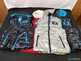 several jackets and jackets are laid out on a black table