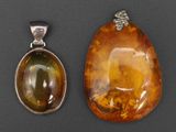 deux morceaux d'ambre et un pendentif en argent sur un fond noir