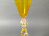 an image of a yellow wine glass sitting on top of a table