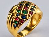 gros plan d'une bague en or avec des pierres multicolores