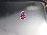 a british flag sticker on the back of a silver suitcase