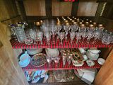 many empty wine glasses on a shelf in the kitchen