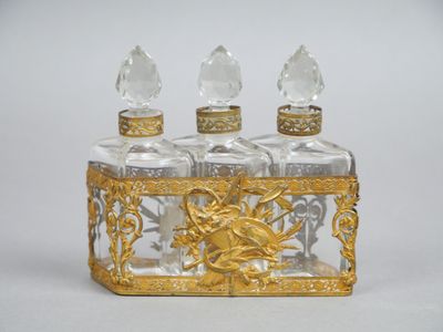 une bouteille en verre ornée d'un décor doré sur le goulot