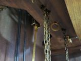 a clock that has chains hanging from it ' s side