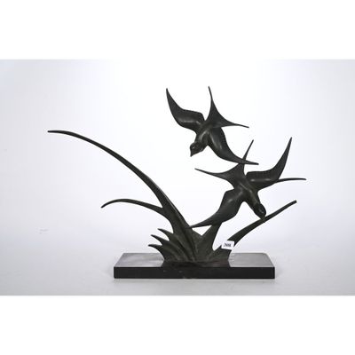 une image représentant une sculpture de deux poissons posée sur un socle en pierre