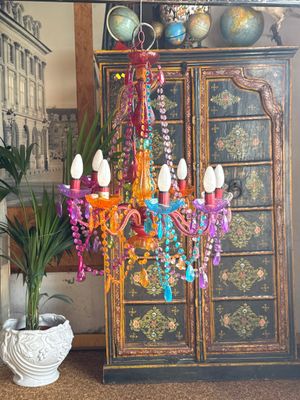 a colorful chandelier hanging from the ceiling in a living room
