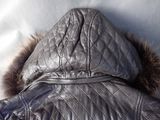 leather jacket with hood and fur trims laying on a bed