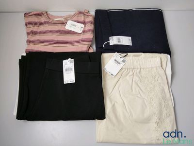 three pairs of women ' s pants with tags on them sitting on a table