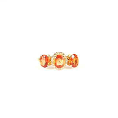 a close up of an orange and white diamond ring on a white background