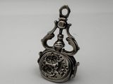 an antique silver pocket watch with a chain hanging from it ' s side
