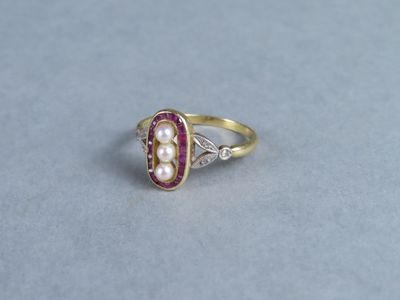 an image of a pearl and diamond ring on a table