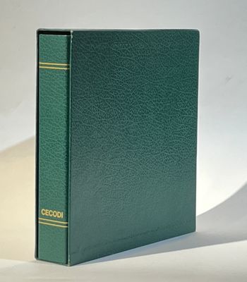 un livre vert posé sur une table à côté d'un mur blanc