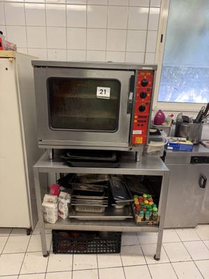 un micro-ondes argenté posé sur un support métallique dans une cuisine