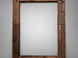a close up of a mirror on a wall with a wooden frame