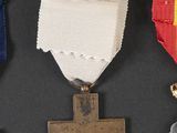 three medals and a cross on a black surface