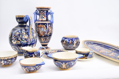 many pieces of blue and white pottery sitting on a table