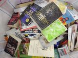 une pile de livres dans un sac posé sur un lit