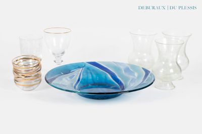 un bol bleu et blanc et des verres posés sur une table