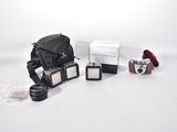 a camera, a camera case, and other items on a white surface