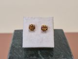 a pair of earrings sitting on top of a marble block