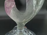 a glass vase with a pink flower on top of it