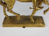 bronze statue of a man riding a horse on a base