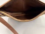 the inside of a brown and tan purse with a brown strap