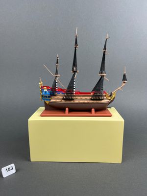a small model of a wooden ship on a yellow stand