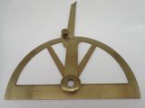 une vieille plaque en laiton sur laquelle est posé un instrument de mesure