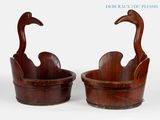 pair of wooden ducks in a wooden bucket on a white background