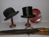 trois chapeaux et un parapluie posés sur une table