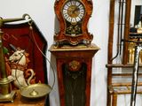 une horloge posée par terre à côté d'une chaise