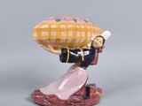 une figurine représentant une femme portant un panier sur la tête