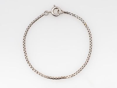 un bracelet en argent avec une chaîne sur fond blanc