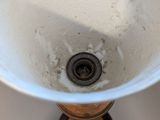 a white sink with a metal faucet in it