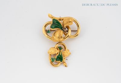 an image of a gold brooch with green leaves on it