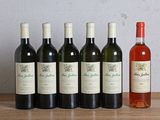 six bottles of wine sitting on a table next to a bottle of wine