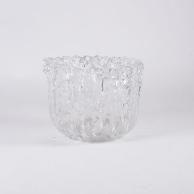 un gros plan d'un vase en verre transparent posé sur une surface blanche