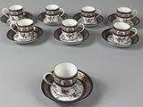 nine cups and saucers sitting on a table